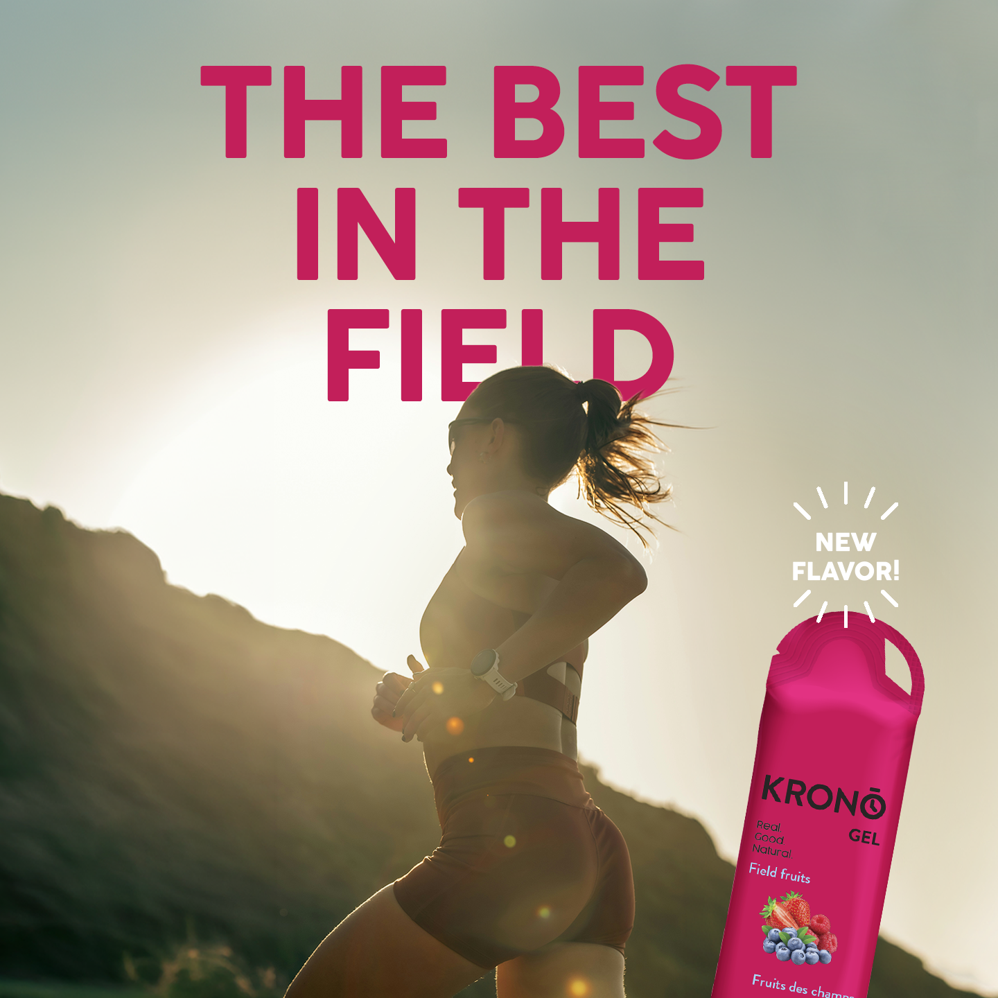 Woman running with a pink KRONO energy gel bottle and 'The Best in the Field' text on a mountain background