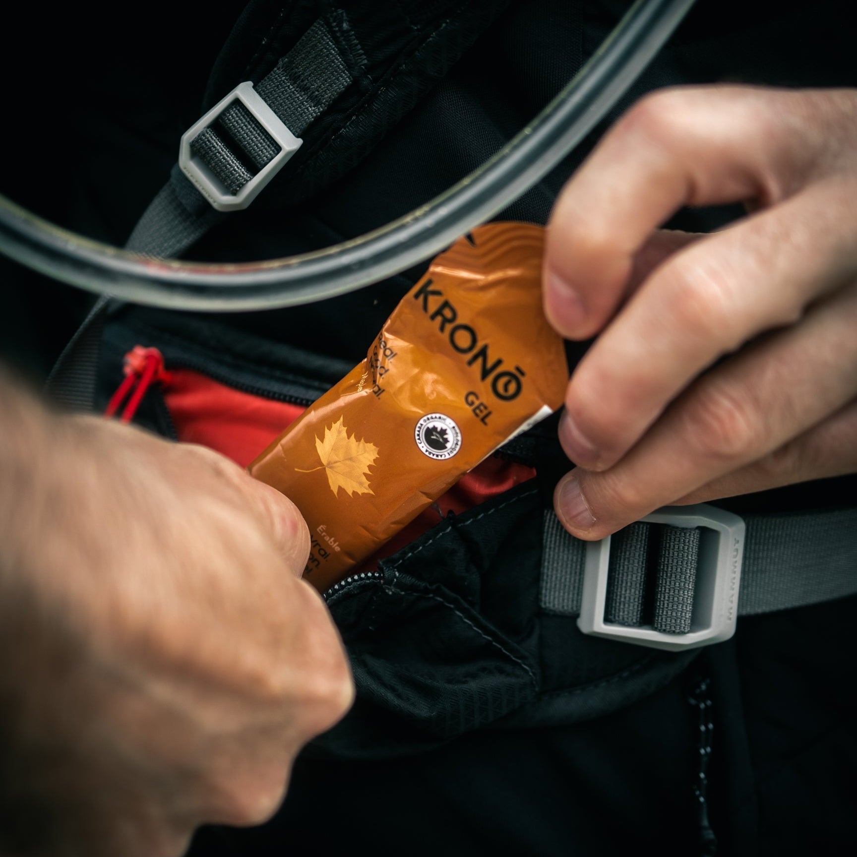Runner taking out a Krono Nutrition maple energy gel from his running vest, outdoors