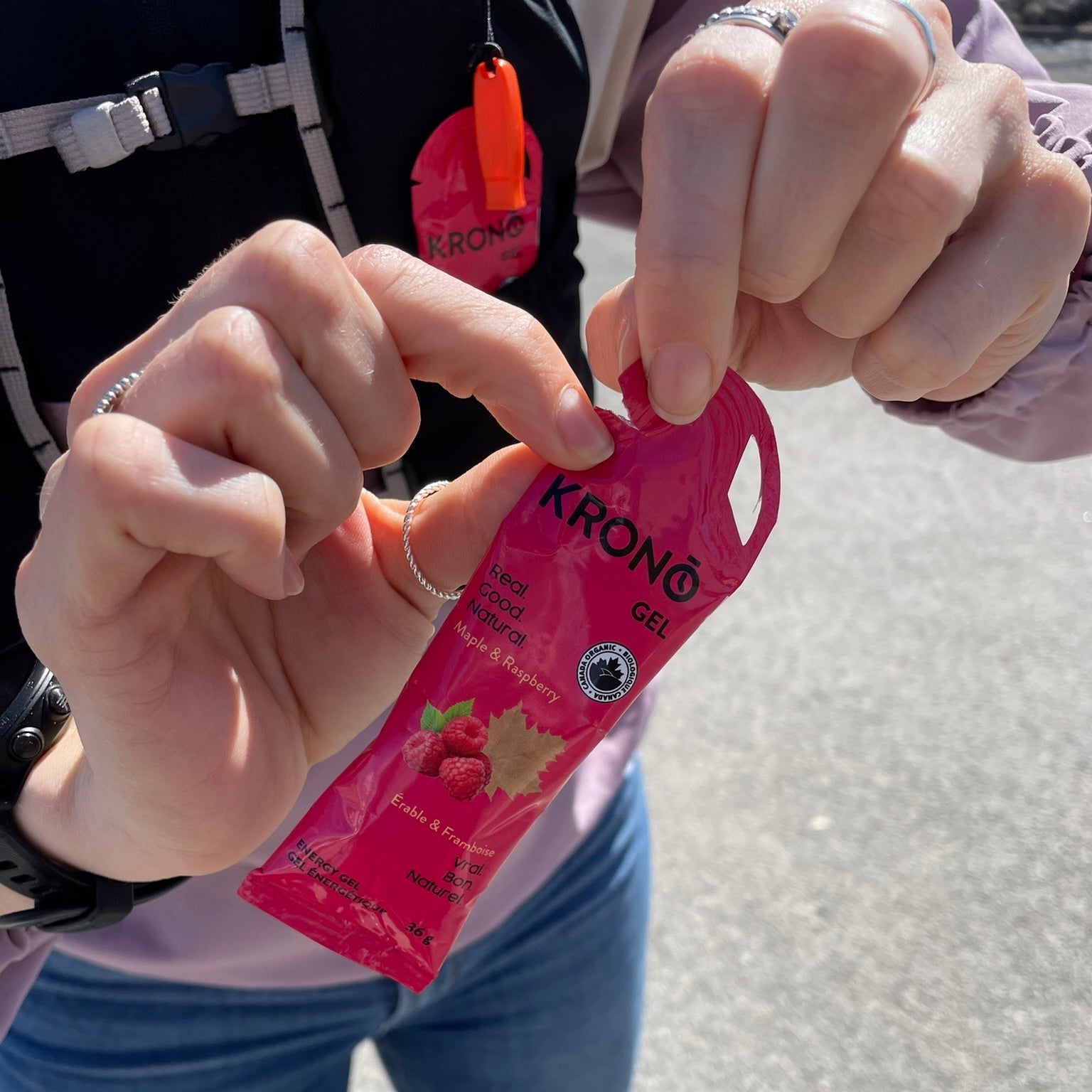 Close-up of runner opening Krono Nutrition maple and raspberry energy gel, outdoors