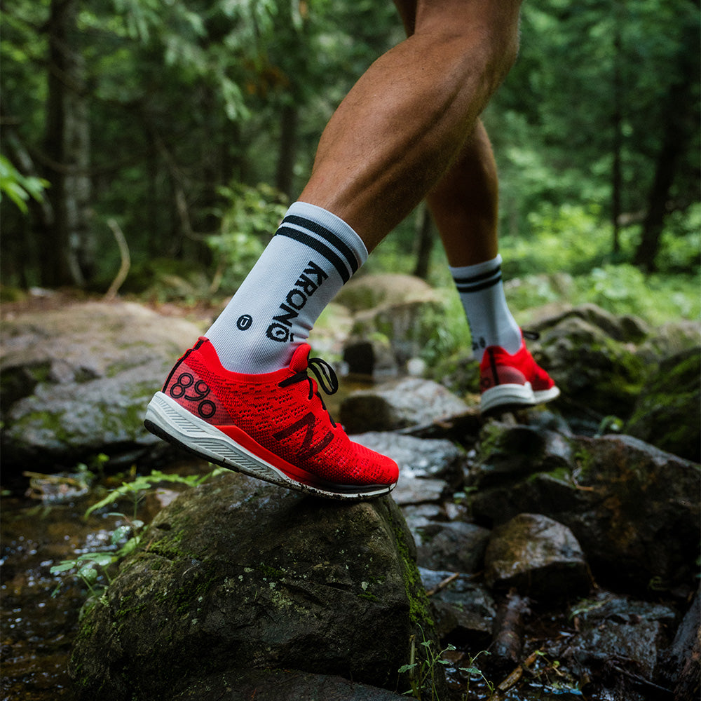 Runner wearing Krono Nutrition socks vintage OUTWAY, white and black, on a rocky trail