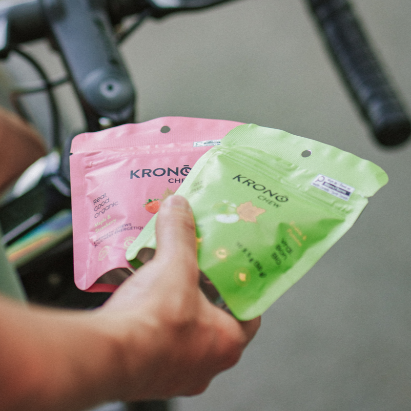 Person holding two packages, one pink and one green, with 'Krono' branding.