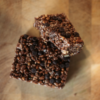 Two chocolate chip cookie bars on a wooden surface