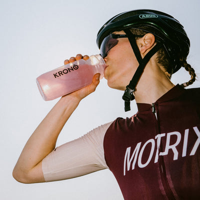 Cyclist drinking a Krono Nutrition pink lemonade effervescent tablets mix, outdoors