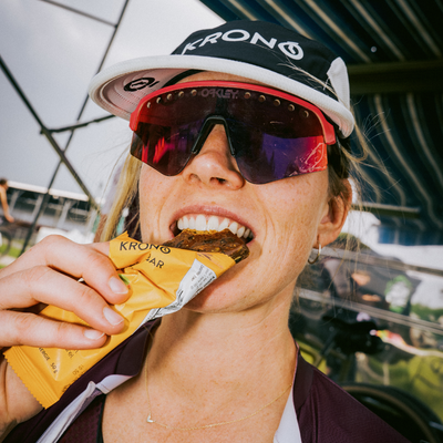 Cyclist taking a bite out of a Krono Nutrition apricot and cranberry energy bar
