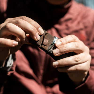 Close-up of Krono Nutrition brownie protein bar being broken in two pieces