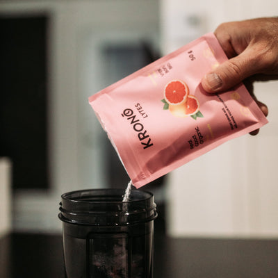 Person mixing his Krono Nutrition pink lemonade sport drink mix, 50g, in a water bottle