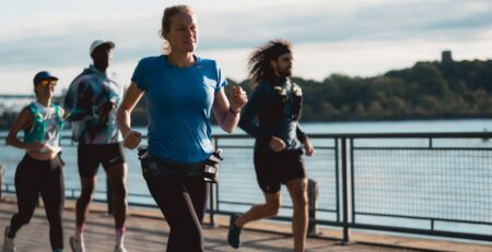 Quatre coureurs à l'entraînement en ville, au bord de l'eau, courant en zone facile, soit la zone 1