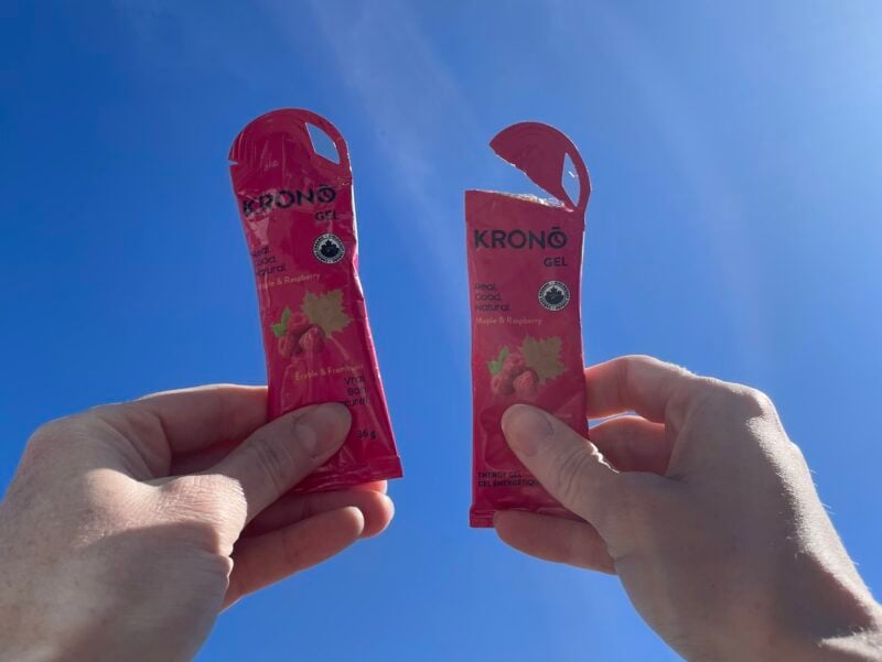 Deux sachets de gel énergétique à saveur de Framboise et érable, ouverts, sur fond de ciel bleu.